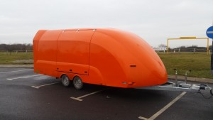Orange enclosed vehicle trailer in a carpark