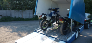 Motorbikes in a blue enclosed trailer