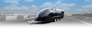 Black enclosed race trailer in front of the image of a race track