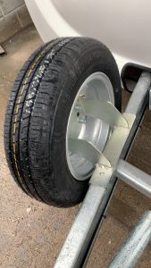 Tyre on the front fitting of a white trailer