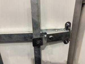 Metal clamp fixed to a white trailer