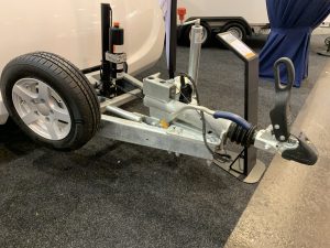 Close up of a stripped down trailer hitch with an alloy wheel attached on the side