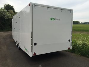 rear three quarter shot of a large white enclosed vehicle trailer