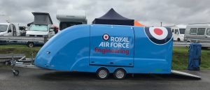 Blue enclosed vehicle trailer with the royal air force engineering logo on
