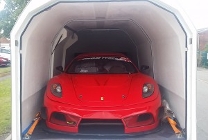 Ferrari 360 race car in the back of a white enclosed vehicle trailer