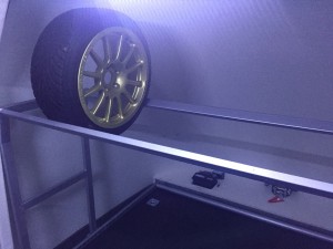 Gold wheel on a tyre rack inside a white trailer