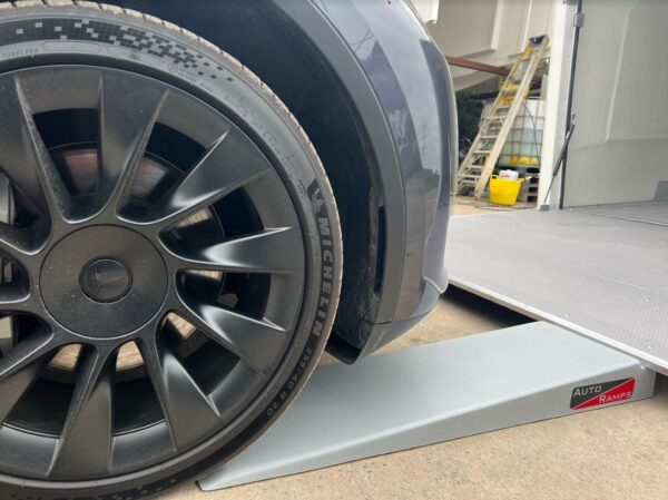Car going up ramp with black wheel rim with Michelin tyres