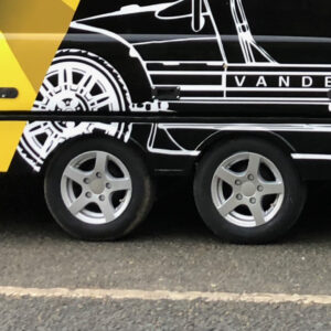 Alloy wheels on a black and yellow trailer with a white graphic on the side