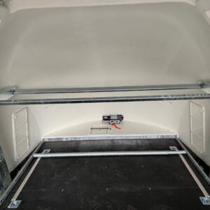 Silver tyre rack fixed to a white enclosed vehicle trailer