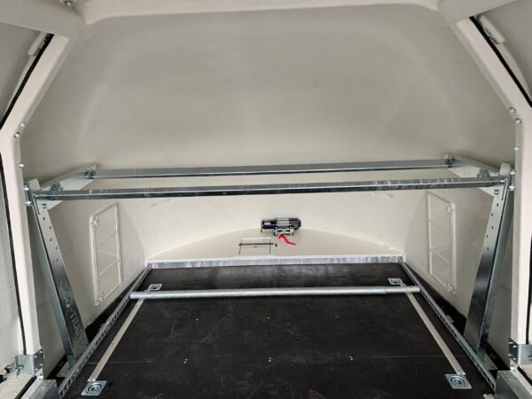 Silver tyre rack fixed to a white enclosed vehicle trailer