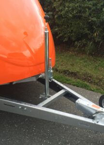 Silver tilt mechanism attached to an orange trailer