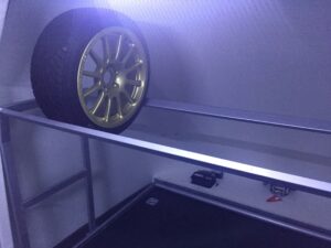 Gold wheel on a small shelf inside a white trailer