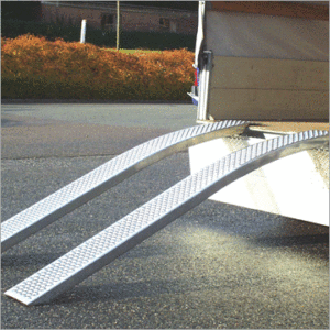 Curved aluminium ramps out the back of a trailer in a carpark