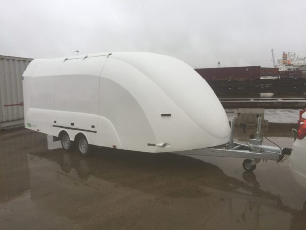 White enclosed vehicle trailer in a wet car park