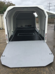White trailer with the ramps down showing off the inside