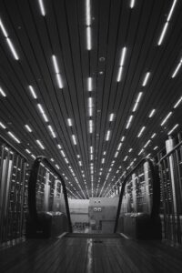 Black and white image on led lights on a roof above an escalator